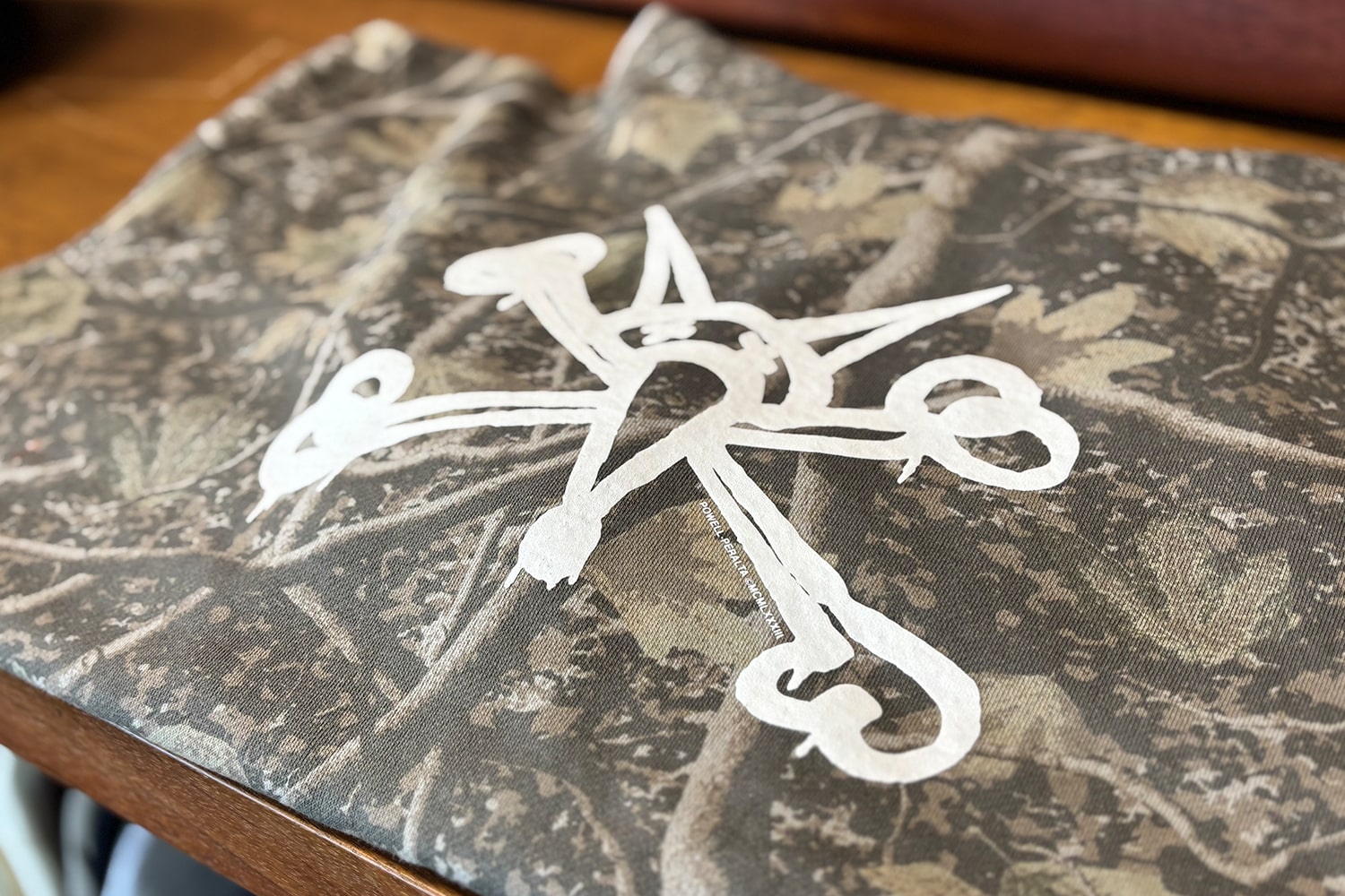 flat Deadwood Tree Camo hoodie over the top of a field